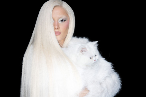 Zara Larsson portrait against a black background with a cat for Allure's cover shoot